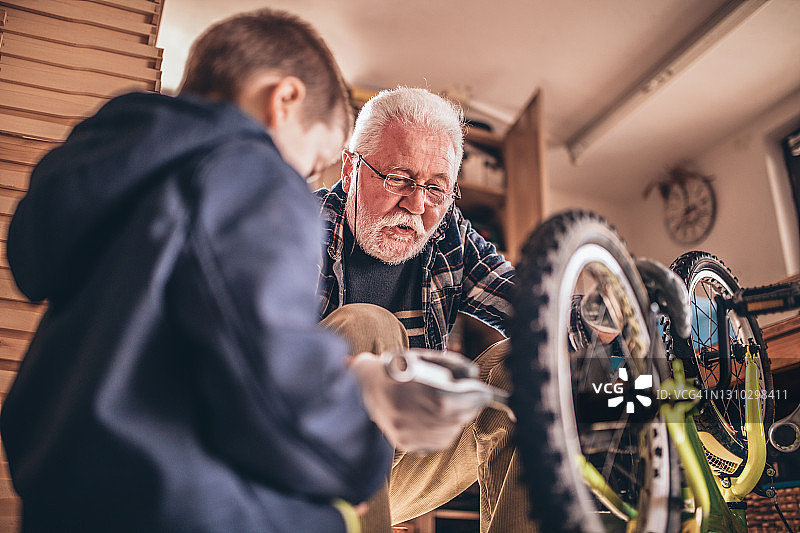 祖父和孙子在工作室修理自行车图片素材