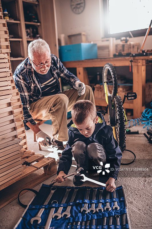 祖父和孙子在工作室修理自行车图片素材