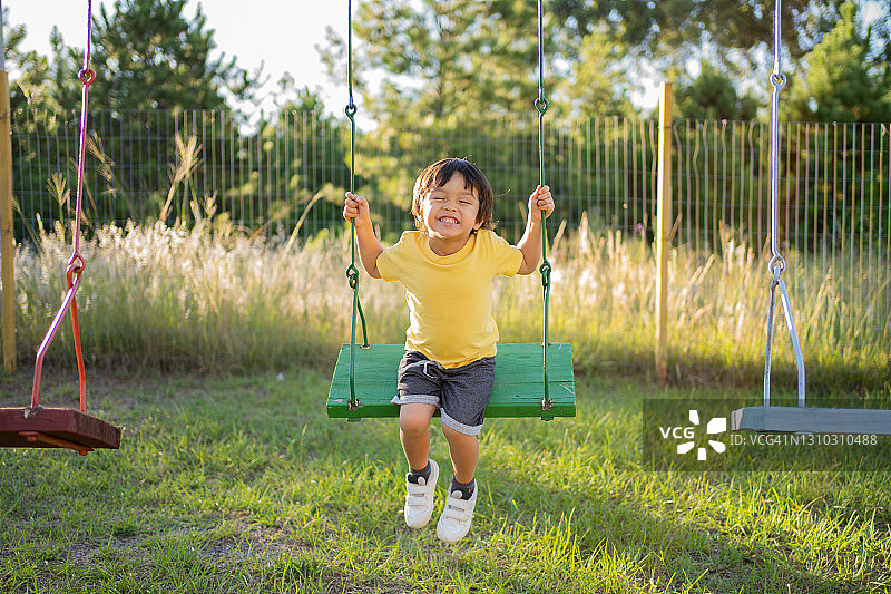 快乐的亚洲日本小男孩在游乐场玩耍图片素材