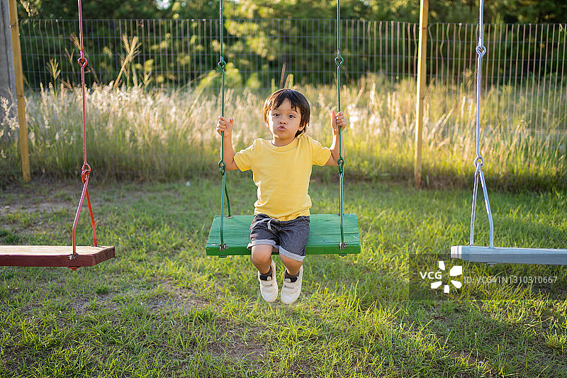 快乐的亚洲日本小男孩在游乐场玩耍图片素材