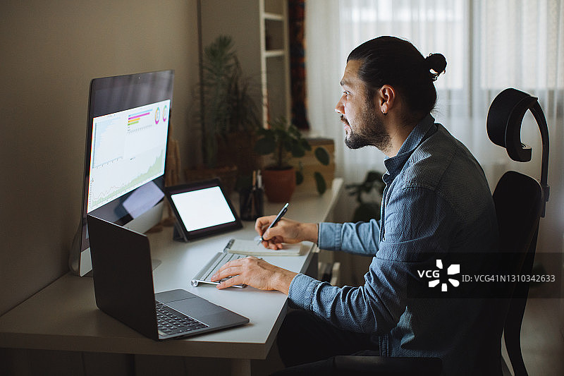 年轻男人在家中办公室使用台式电脑图片素材