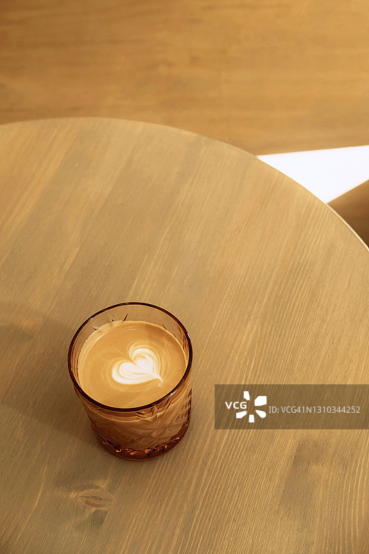 木桌上玻璃杯中的拉花咖啡俯视图图片素材