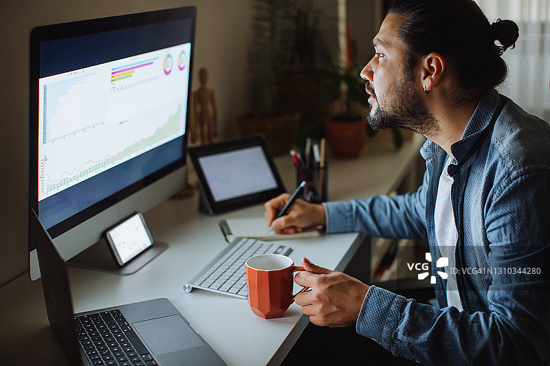 年轻男人在家中办公室使用台式电脑图片素材