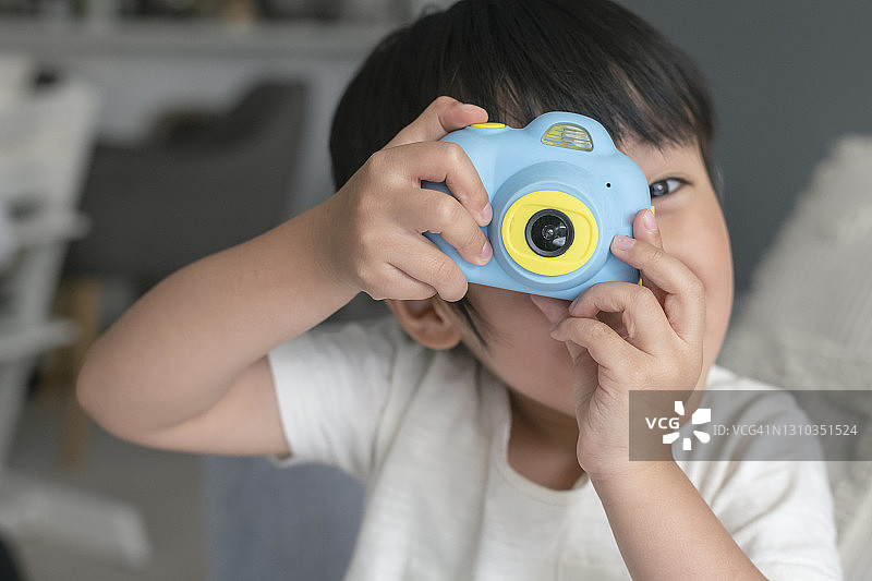 玩玩具相机的可爱幼儿男孩图片素材