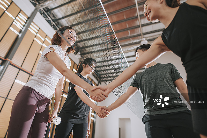 低角度拍摄的亚洲女子运动员握手，展现良好体育精神图片素材