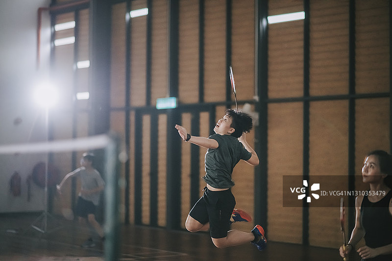 中国女子羽毛球运动员在羽毛球场上跳跃图片素材
