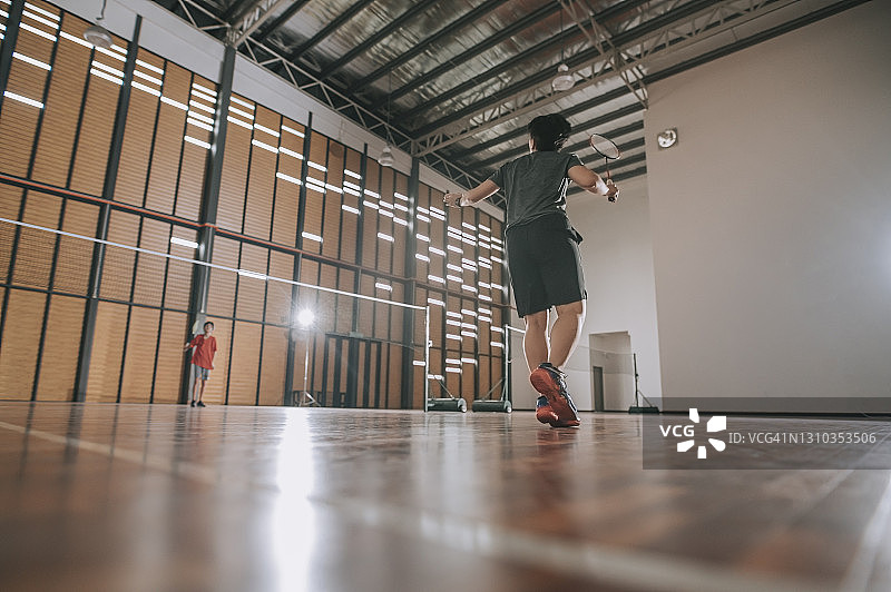 在羽毛球场上打球的亚洲羽毛球女运动员图片素材