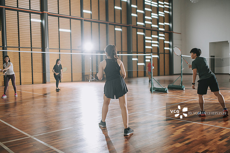 在羽毛球场上打球的亚洲华人女羽毛球运动员图片素材