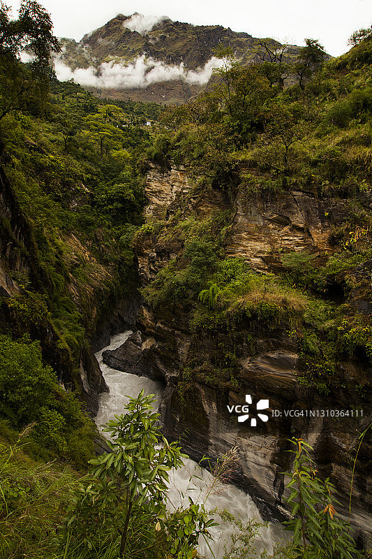 卡利甘达基河沿岸茂盛的绿色植物和崎岖的山坡，河流经过贝尼到宗索姆的宗索姆萨达克公路上的安德加尔奇的狭窄峡谷图片素材