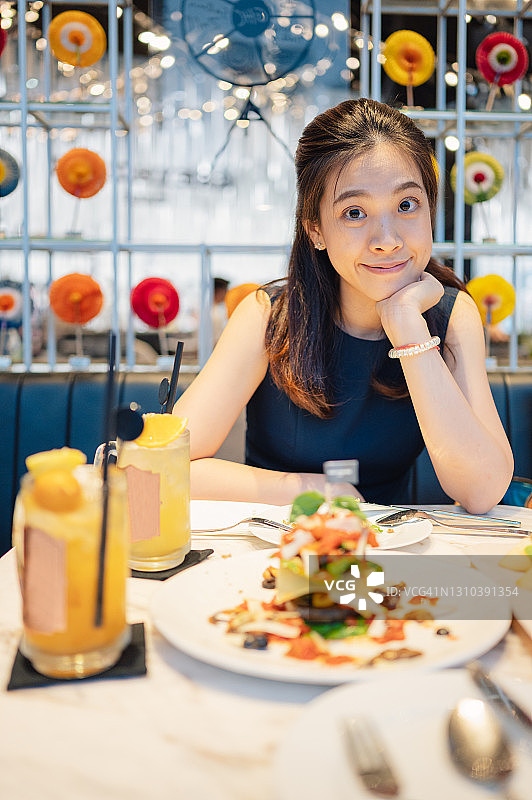 竖版：快乐的亚洲女人享受美食，展现快乐的情绪图片素材