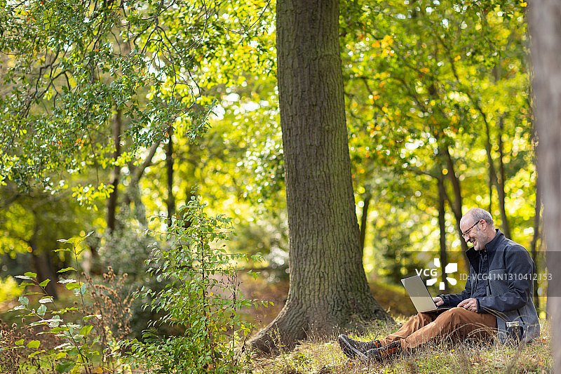 男人在户外使用笔记本电脑工作图片素材