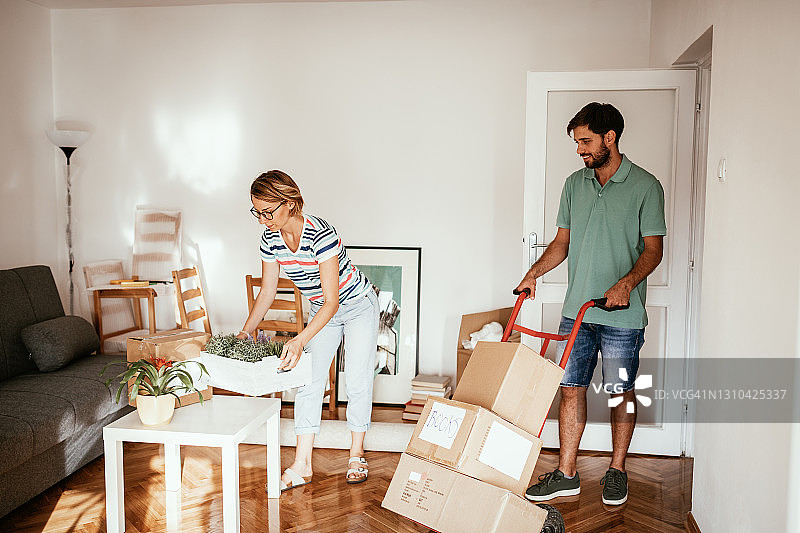 搬家：一家人在新公寓里拆箱整理图片素材
