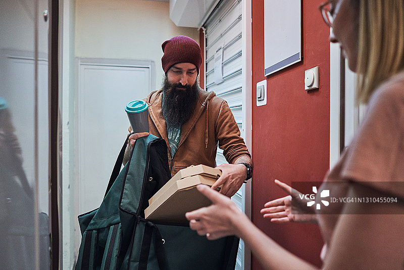 现代食品配送员：为女性顾客配送披萨和咖啡图片素材