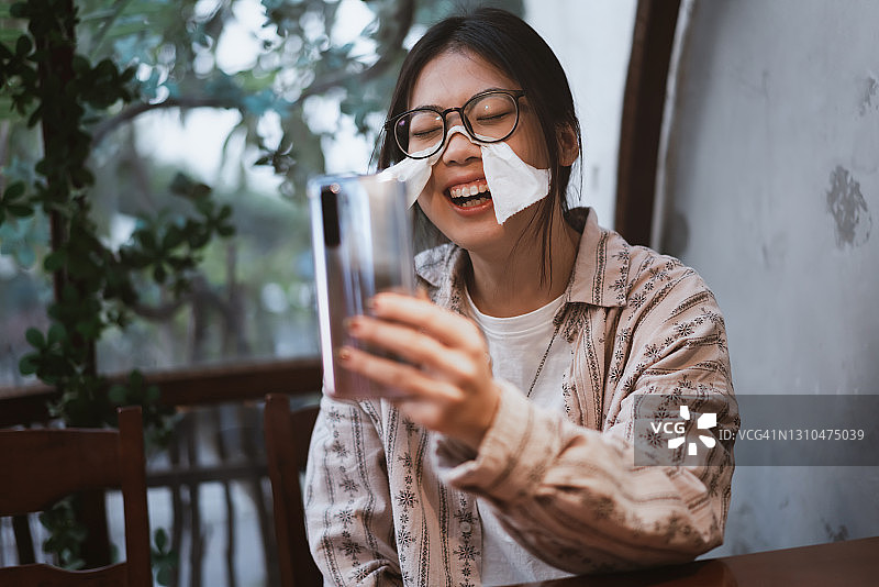 中国女孩在手机上进行视频通话时微笑图片素材