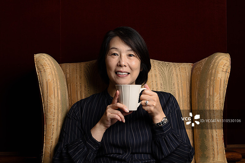 笑容满面的女子坐着喝咖啡图片素材