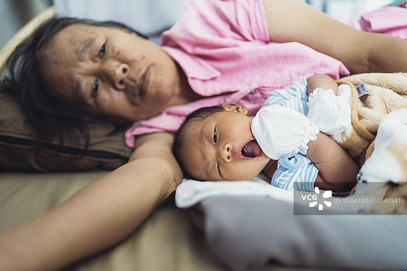 祖母在家抱着新生婴儿睡觉图片素材