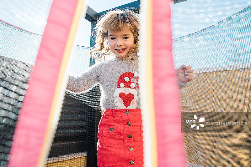 在蹦床上跳跃的金发小女孩图片素材