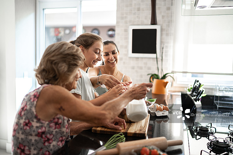 多代同堂家庭在家中准备面包/蛋糕图片素材