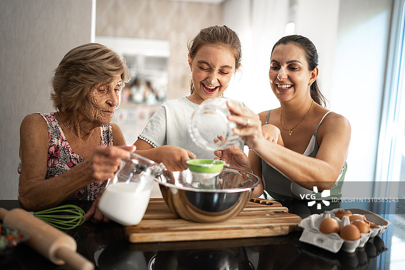 多代同堂家庭在家中准备面包/蛋糕图片素材