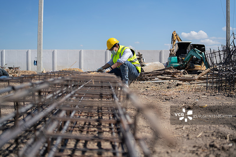 在工地工作的亚洲男子：建筑工人与专业工程师图片素材