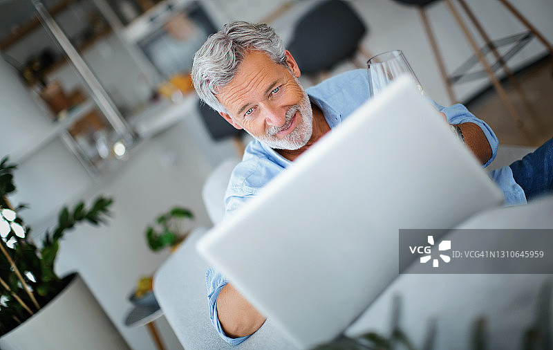 年长的男人在家使用笔记本电脑图片素材