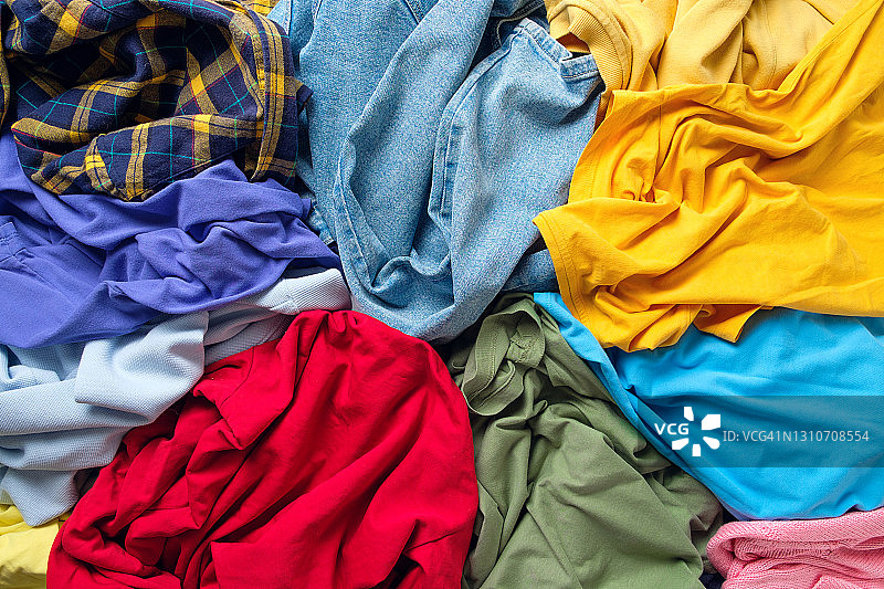 大量明亮、脏乱、色彩缤纷的散落衣服，抽象背景，家庭作业的概念，缺乏做家务的时间图片素材