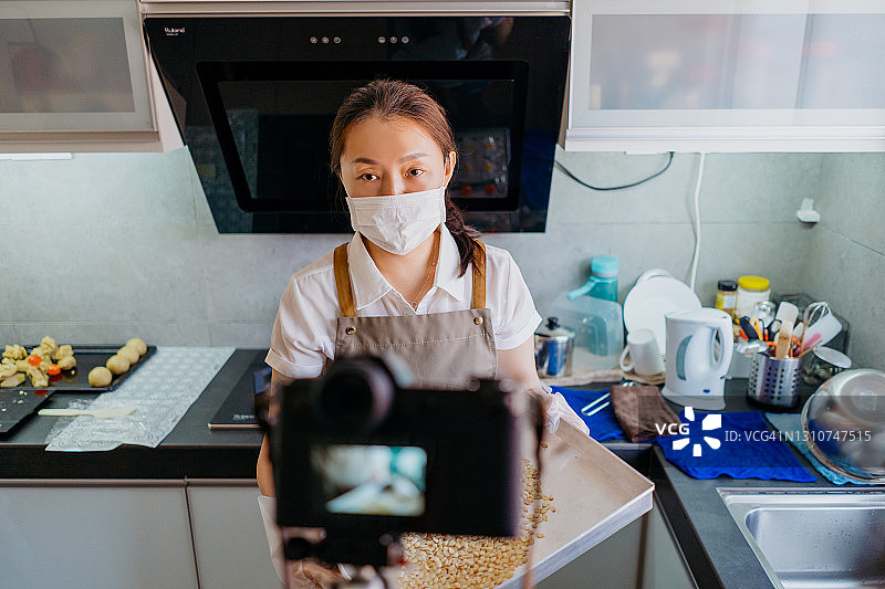 在家录制烘焙视频的亚洲女性Vlogger图片素材