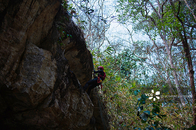 年轻亚洲登山者攀登泰国北部高耸悬崖图片素材