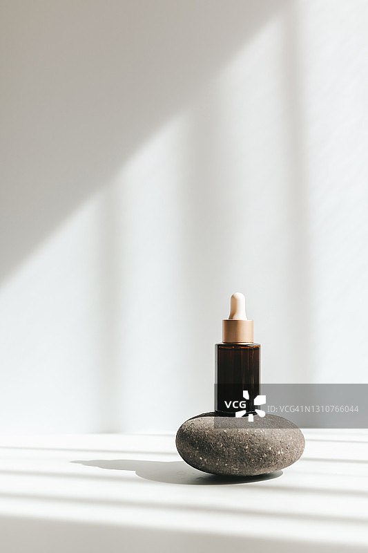 灰色背景上的棕色玻璃滴管化妆油瓶模型图片素材