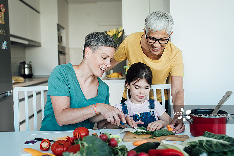 女孩向妈妈和奶奶学习准备蔬菜图片素材