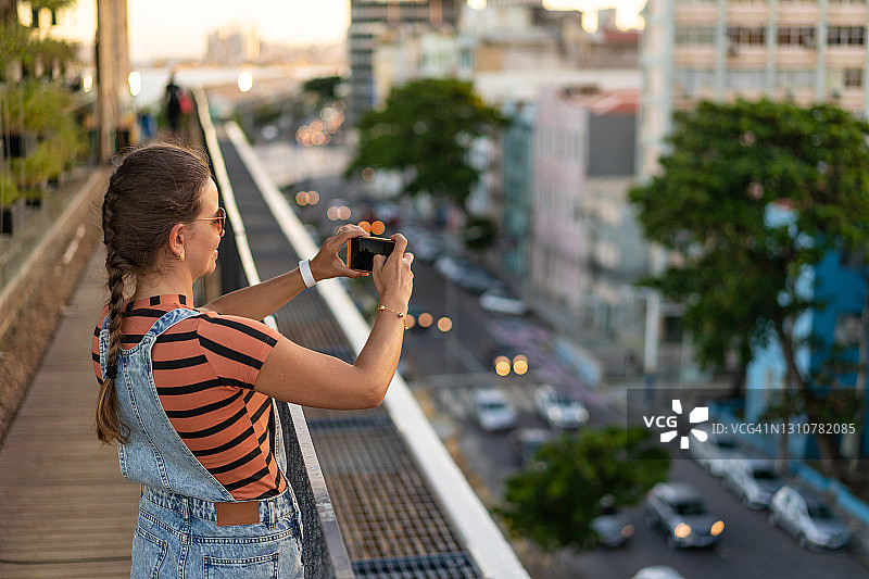 女人用手机拍摄累西腓伯南布哥市的照片图片素材