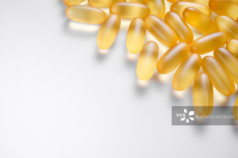 白色背景或木桌上的Omega-3鱼油胶囊图片素材