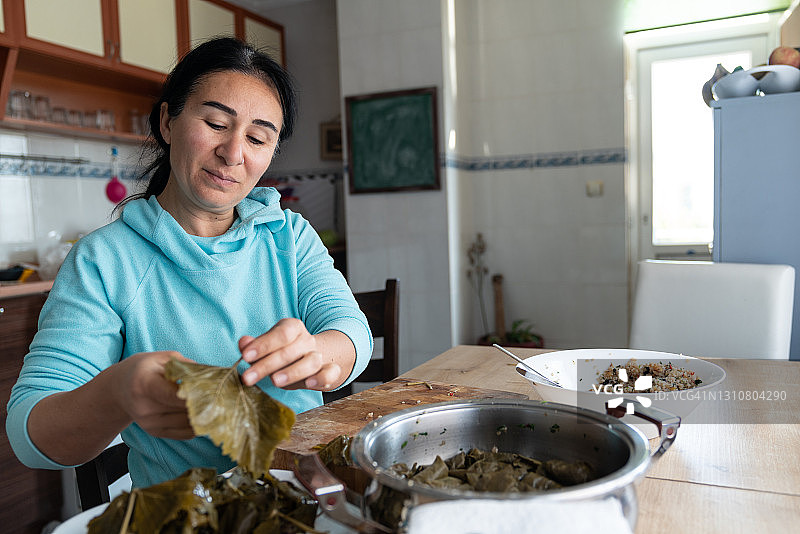 成熟女人在家里厨房准备土耳其食物图片素材