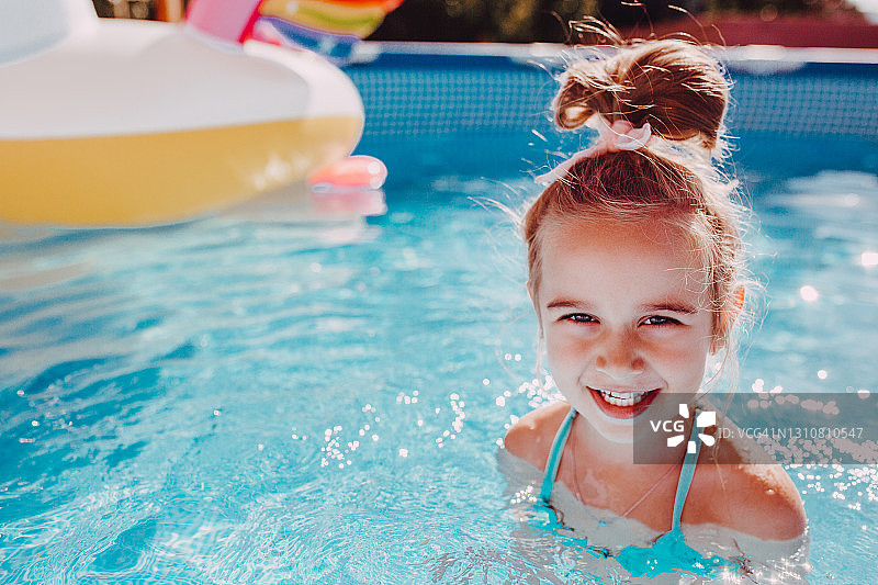 女孩在泳池里享受泡泡糖图片素材
