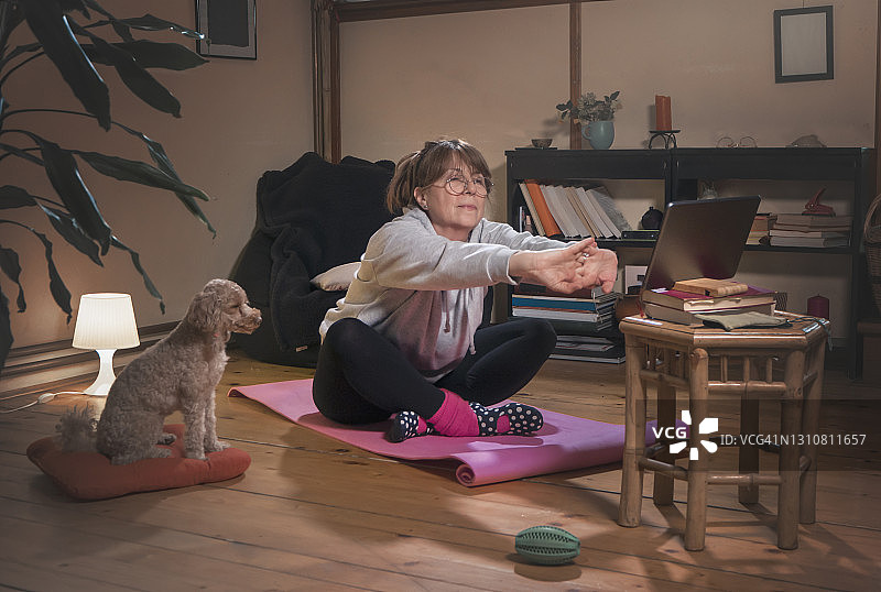 中年妇女锻炼并观看在线健身视频图片素材