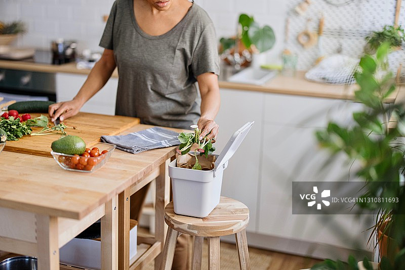 女人将有机废弃物放入堆肥箱图片素材
