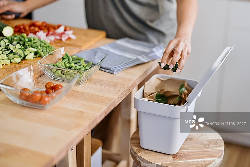 女人将有机废弃物放入堆肥箱图片素材