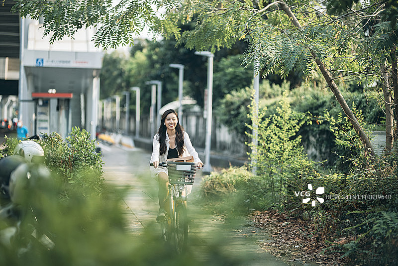 户外骑自行车的年轻亚洲女性图片素材