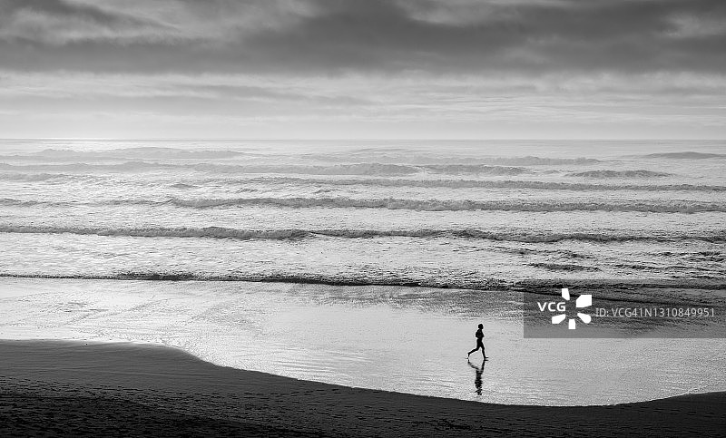 一人在海滩上慢跑图片素材