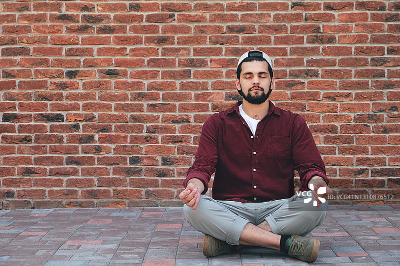 平静的印度男子在鹅卵石上冥想图片素材