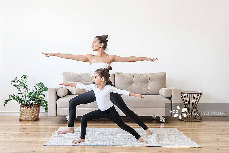 幸福的家庭：妈妈和女儿早上在家里做瑜伽图片素材