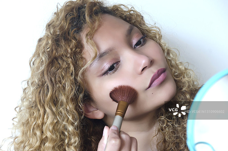 年轻漂亮女子涂抹腮红图片素材