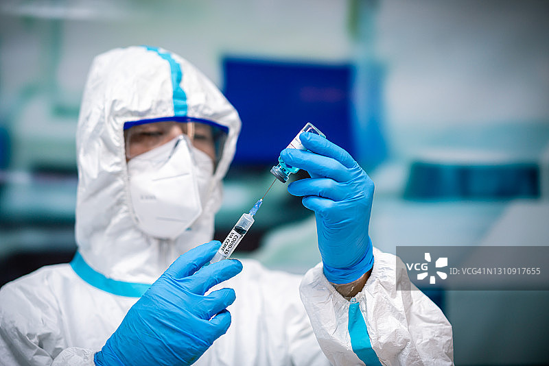 拿着新冠疫苗的亚洲男医生图片素材