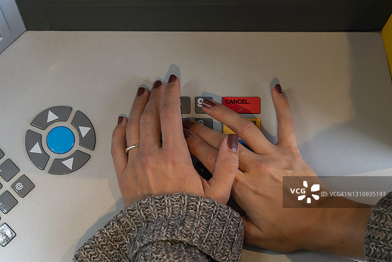 在城市中使用自动取款机的千禧一代女性图片素材