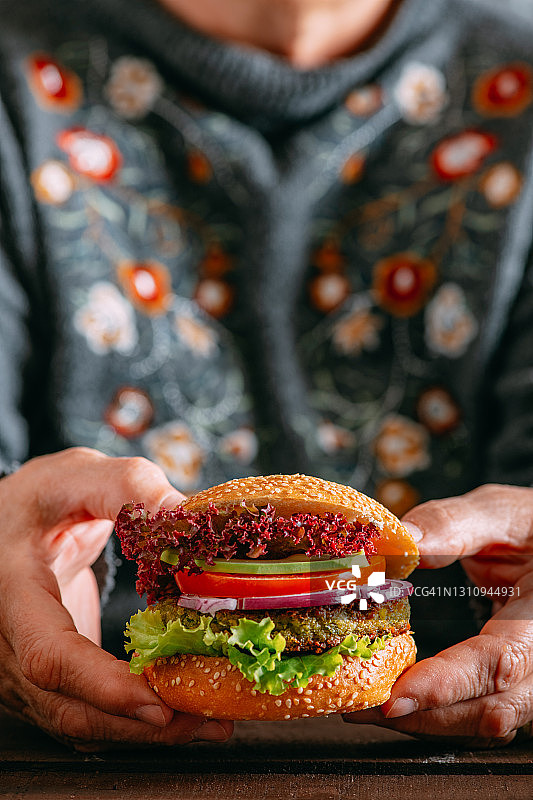 手持纯素汉堡图片素材