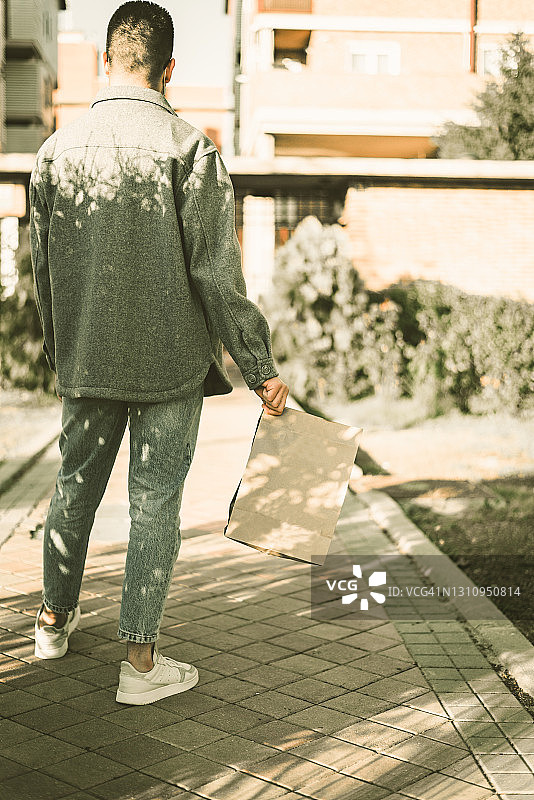 手提食物袋的年轻男人图片素材