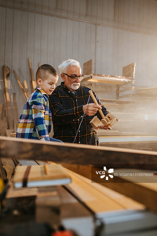 男孩和爷爷在木工车间图片素材