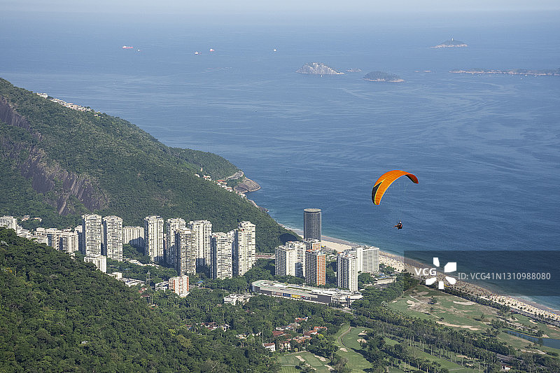 滑翔伞飞越居民楼的美丽景色图片素材