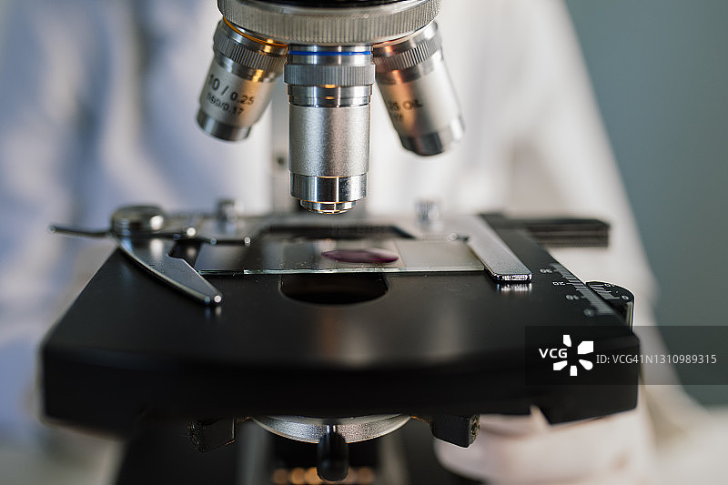 实验室技术员用显微镜检查样品特写图片素材