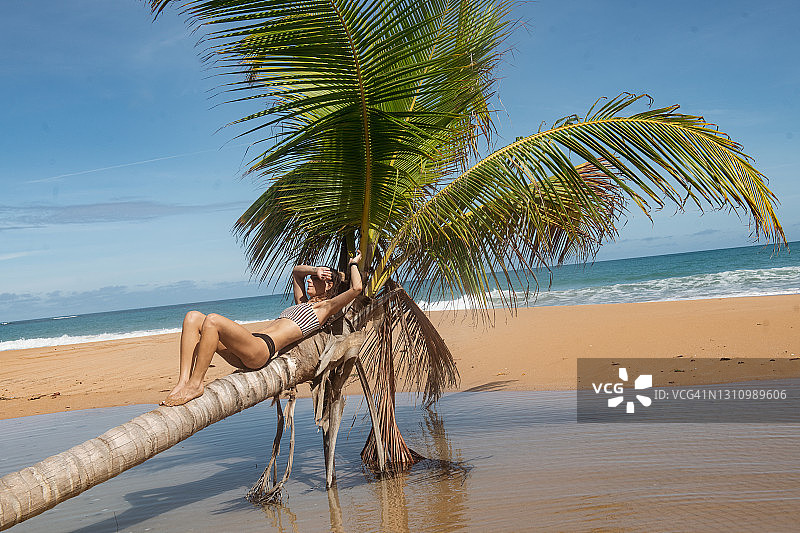 女孩和棕榈树在波多黎各海滩休闲图片素材